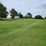 Panoramic view of a lush green golf course at Pinecrest Golf Course. Smooth