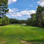 Panoramic view of a lush green golf course at Pinehills Golf Club. Smooth