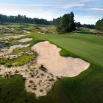 Panoramic view of a lush green golf course at Pinehurst No. 4. Smooth