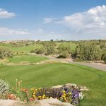 Panoramic view of a lush green golf course at Pinon Hills Golf Course. Smooth