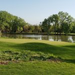 Panoramic view of a lush green golf course at Pioneers Golf Course. Smooth