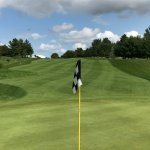Panoramic view of a lush green golf course at Pleasant View Golf Course. Smooth