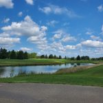 Panoramic view of a lush green golf course at Plum Creek Golf Club. Smooth
