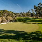 Panoramic view of a lush green golf course at Poppy Hills Golf Course. Smooth