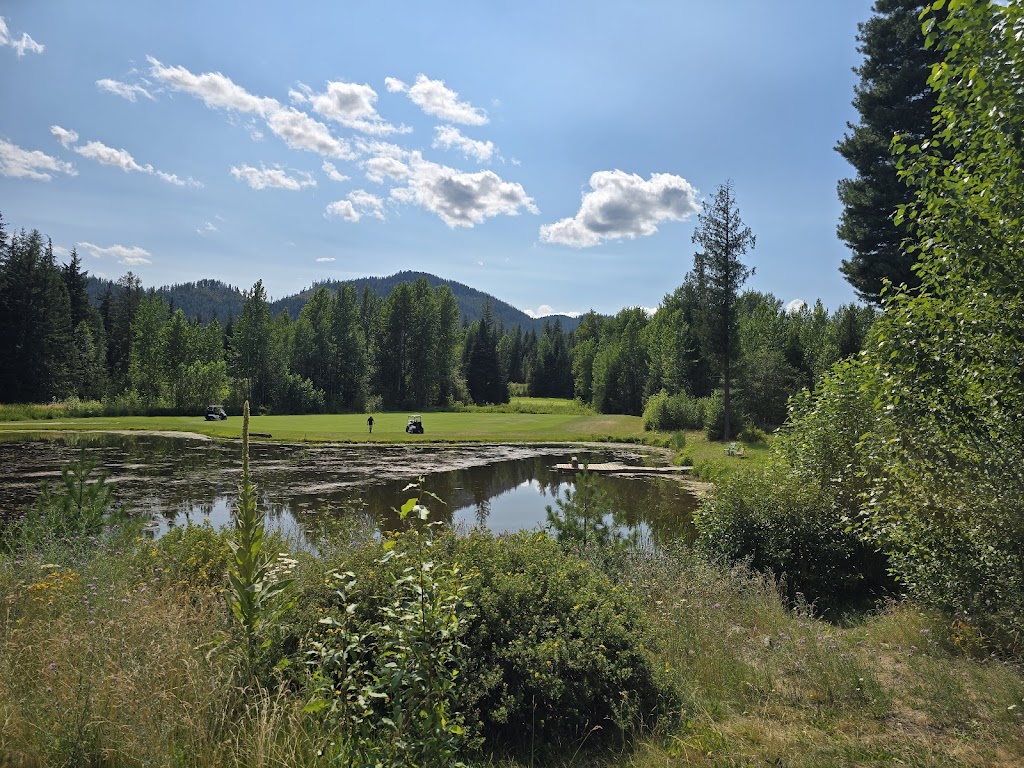 Panoramic view of a lush green golf course at Priest Lake Golf Course. Smooth