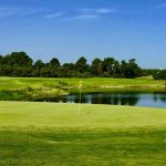 Panoramic view of a lush green golf course at Providence Golf Club. Smooth
