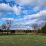 Panoramic view of a lush green golf course at Quail Brook Golf Course. Smooth