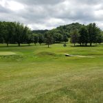 Panoramic view of a lush green golf course at Quail Run Golf Links. Smooth