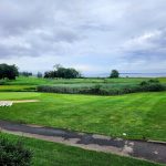 Panoramic view of a lush green golf course at Quidnessett Country Club. Smooth