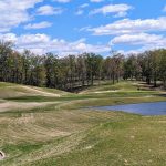 Panoramic view of a lush green golf course at RTJ Golf Trail at The Shoals. Smooth