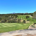 Panoramic view of a lush green golf course at Rainmakers Resort and Club. Smooth