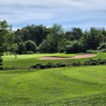 Panoramic view of a lush green golf course at Raritan Landing Golf Course. Smooth