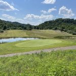 Panoramic view of a lush green golf course at Raven Rock Golf Course. Smooth