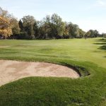 Panoramic view of a lush green golf course at Ravisloe Country Club. Smooth