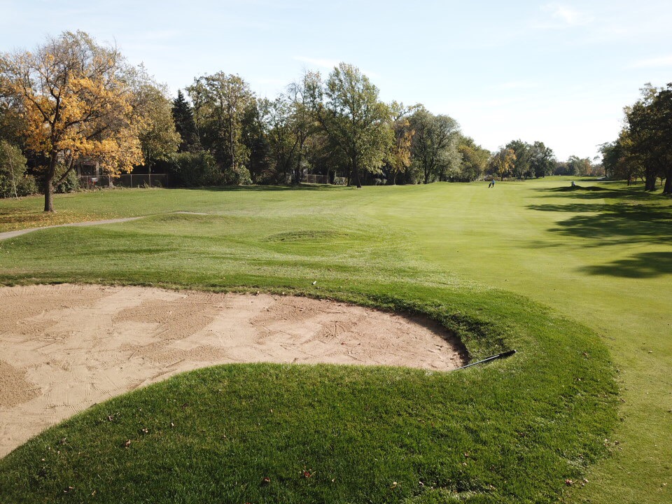 Panoramic view of a lush green golf course at Ravisloe Country Club. Smooth