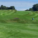 Panoramic view of a lush green golf course at Raymond C. Firestone Public 9. Smooth
