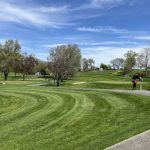 Panoramic view of a lush green golf course at Red Wolf Golf Club. Smooth