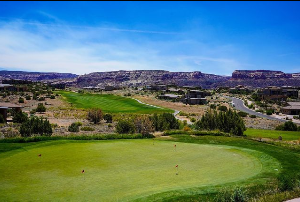 Panoramic view of a lush green golf course at Redlands Mesa Golf Course. Smooth
