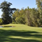 Panoramic view of a lush green golf course at River Oaks Golf Club. Smooth