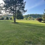 Panoramic view of a lush green golf course at Riverbend Golf Course. Smooth