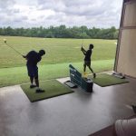 Panoramic view of a lush green golf course at Riverside Golf Academy. Smooth