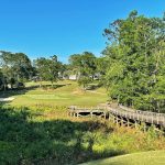 Panoramic view of a lush green golf course at Rock Creek Golf Club. Smooth