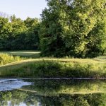 Panoramic view of a lush green golf course at Rock Hollow Golf Club. Smooth