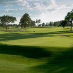 Panoramic view of a lush green golf course at Rockwind Community Links. Smooth