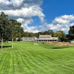 Panoramic view of a lush green golf course at Round Hill Club. Smooth