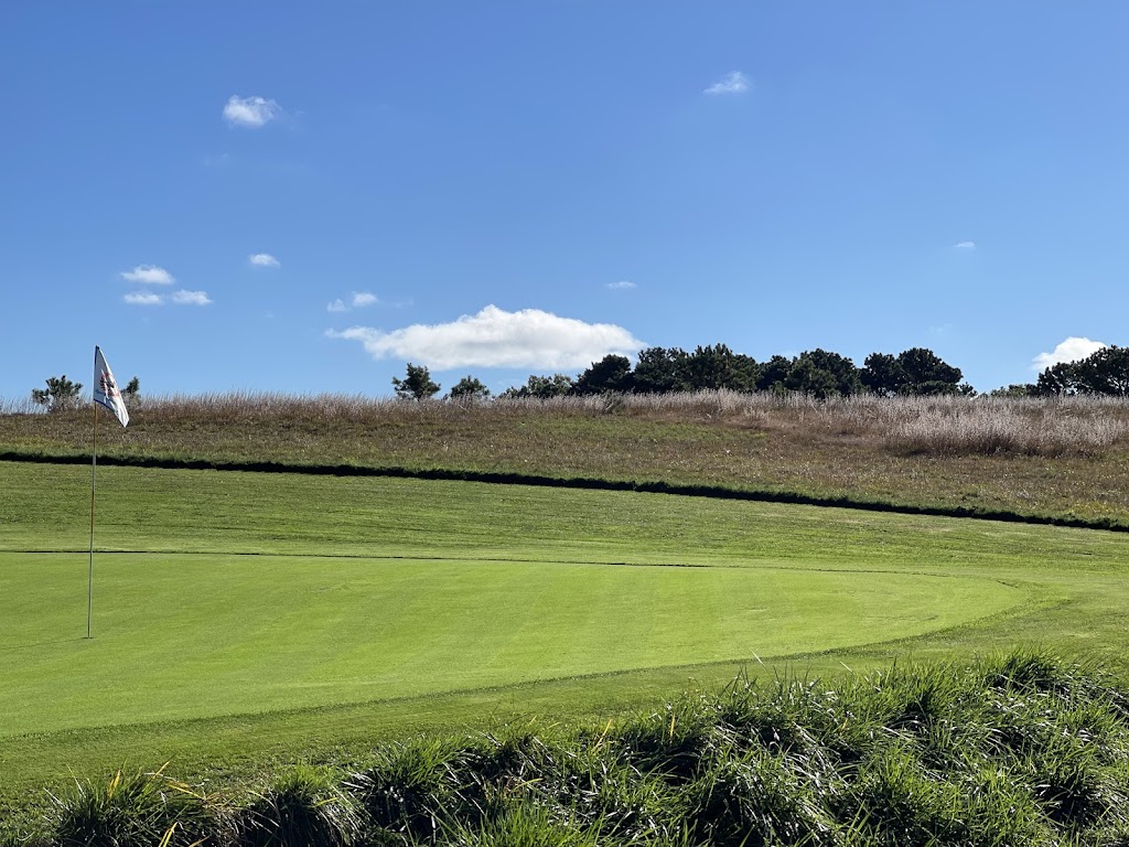 Panoramic view of a lush green golf course at Royal and Ancient Chappaquiddick Links. Smooth