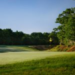 Panoramic view of a lush green golf course at Running Deer Golf Club. Smooth