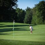 Panoramic view of a lush green golf course at Sagamore-Hampton Golf Club. Smooth