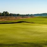 Panoramic view of a lush green golf course at Sage Run Golf Course. Smooth