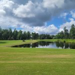 Panoramic view of a lush green golf course at Sanctuary Golf Club. Smooth