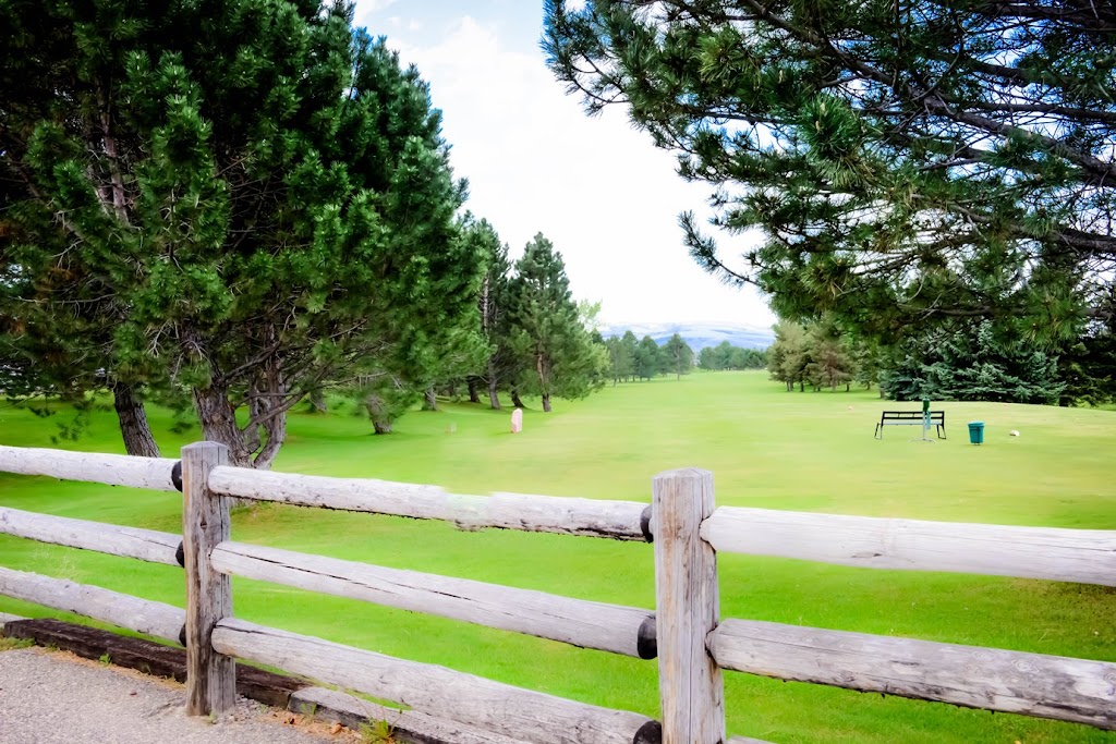 Panoramic view of a lush green golf course at Sand Creek Golf Course. Smooth
