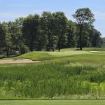 Panoramic view of a lush green golf course at Sand Ridge Golf Club. Smooth