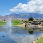 Panoramic view of a lush green golf course at Sandia Golf Club. Smooth