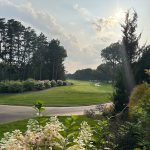 Panoramic view of a lush green golf course at Sandy Pines Golf Club. Smooth