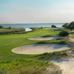 Panoramic view of a lush green golf course at Seaside Golf Course. Smooth