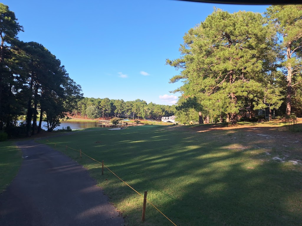 Panoramic view of a lush green golf course at Seven Lakes Country Club. Smooth