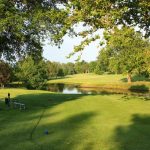 Panoramic view of a lush green golf course at Shirkey Golf Course. Smooth