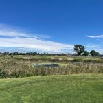 Panoramic view of a lush green golf course at Short Beach Golf Course. Smooth