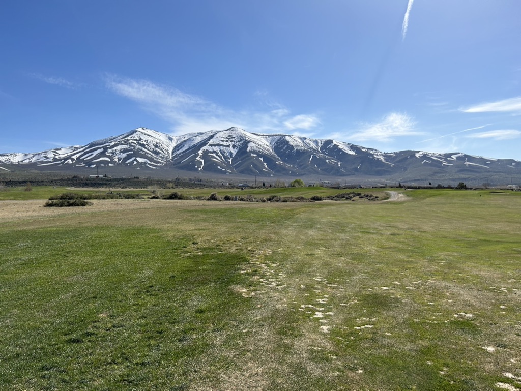 Panoramic view of a lush green golf course at Sierra Sage Golf Course. Smooth