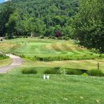 Panoramic view of a lush green golf course at Sleeping Giant Golf Course. Smooth