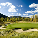 Panoramic view of a lush green golf course at Snake River Sporting Club. Smooth