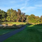 Panoramic view of a lush green golf course at Spook Rock Golf Course. Smooth