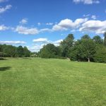 Panoramic view of a lush green golf course at Spooky Brook Public Golf Course. Smooth
