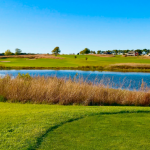 Panoramic view of a lush green golf course at Spring Creek Golf Course. Smooth