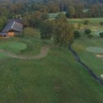 Panoramic view of a lush green golf course at Spring Creek Ranch. Smooth