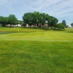 Panoramic view of a lush green golf course at Spring Valley Golf Course. Smooth